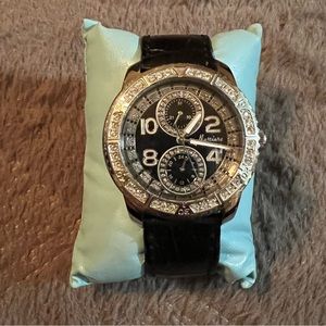 Black and silver watch with leather strap.